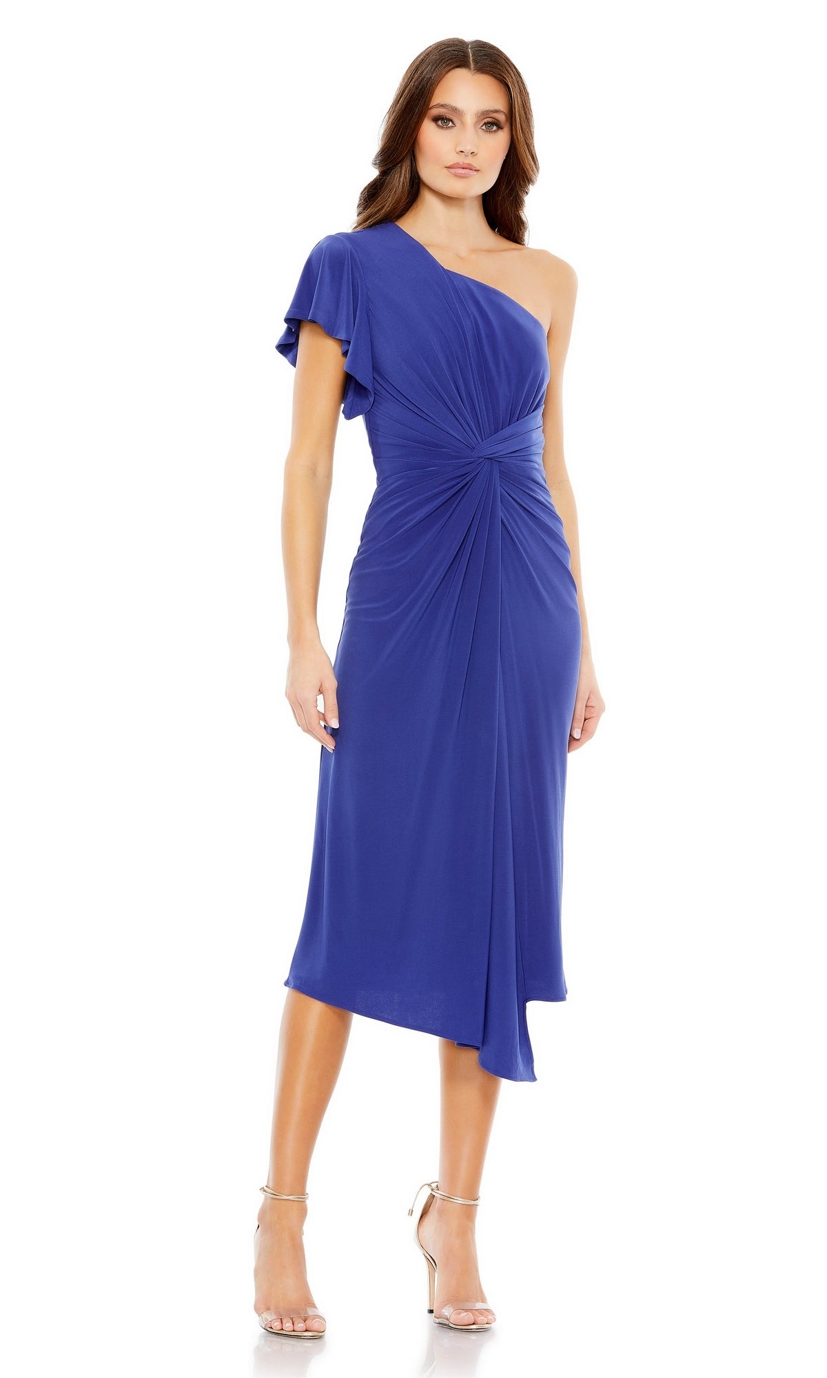A woman wears the Mac Duggal One-Shoulder Knot-Waist Midi Party Dress 12480 in royal blue with draped details, paired with silver high-heeled sandals.